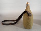 a bottle with a strap attached to it sitting on a table