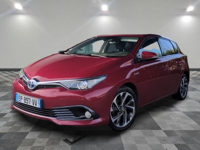 une Toyota Auris hybride rouge garée dans un garage
