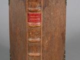 an old book that is open on a gray surface