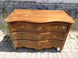 une commode en bois posée sur le trottoir