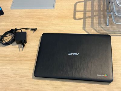 a laptop computer sitting on a desk with a charger