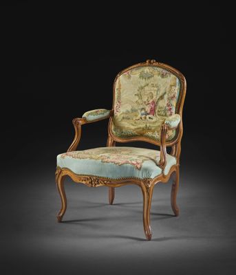 une chaise ancienne dont le dossier et les accoudoirs sont recouverts d'un tissu à motifs floraux