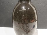 un vase marron posé sur une table blanche