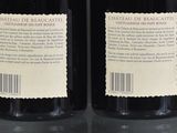 two bottles of wine sitting on top of a table next to each other