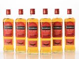 quatre bouteilles de whisky Bushmills « Red Label » alignées les unes à côté des autres