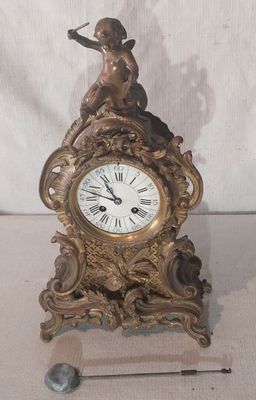 une horloge surmontée d'une statue, à côté d'une aiguille