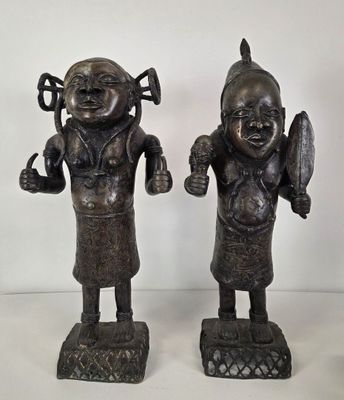 pair of bronze figurines of a man and a woman holding a knife and fork