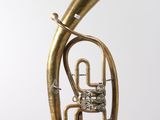 an antique brass french horn on a white background