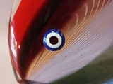 a close up of a glass object with a blue eye on it