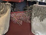 three purses with fringes are lined up on a table