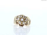 a close up of a gold ring with diamonds on a white surface