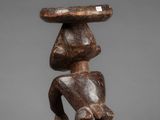 a wooden sculpture of a man with a hat on his head