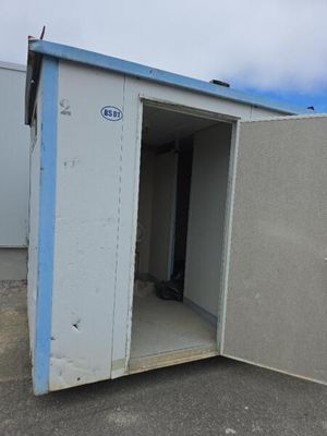 des toilettes portables blanches et bleues installées au milieu d'un parking