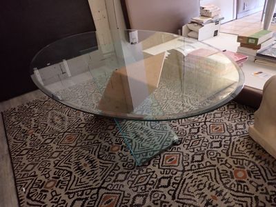 une table en verre avec un plateau en verre posée sur un tapis