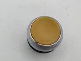 an image of a close up of a yellow button on a white surface