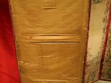 an image of a tall wooden cabinet with a red curtain in the background