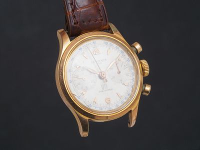 un gros plan d'une montre-bracelet en or avec un bracelet en cuir marron