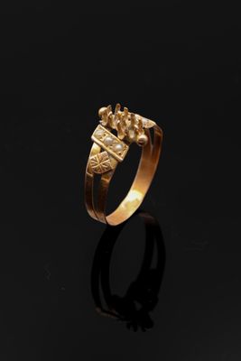 une image représentant une bague en or ornée d'une couronne