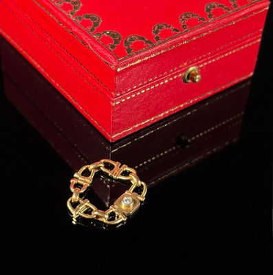 a small red box with a gold brooch on it