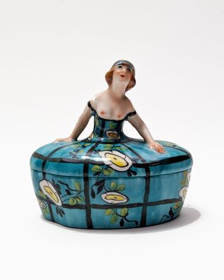 a figurine of a woman sitting on top of a box