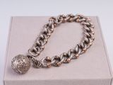 bracelet en argent et en or orné d'une breloque en forme de boule montée sur un fermoir à boîtier