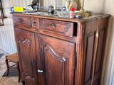 a wooden cabinet in a room with a lamp on top of it
