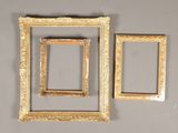 three gold picture frames hanging on a wall next to each other