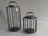 two black metal lanterns sitting next to each other on a white background