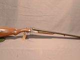 un vieux fusil avec un canon en bois sur fond blanc