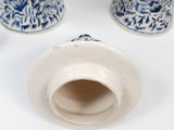 two blue and white vases sitting on a white surface