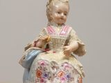 a figurine of a woman sitting on a table