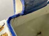 a close up of a blue and white vase with a lion on it