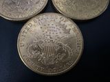 three silver coins sitting next to each other on a black surface