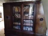 une armoire en bois au milieu d'une pièce où le sol est encombré d'objets divers