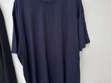 black t - shirt hanging on a hanger next to a pair of black pants
