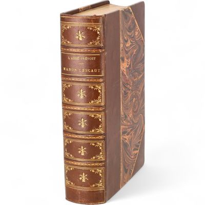 un vieux livre relié en cuir, orné de dorures sur la couverture