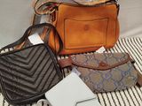 a purse, wallet, and other items that are on a bed