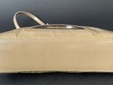 an empty tan purse sitting on top of a black table