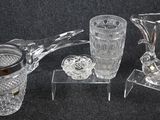 three glass vases and a candle holder sitting on a table