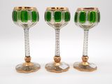 three green glass goblets sitting next to each other on a white surface