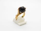 a close up of a ring with a black stone on it