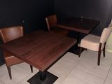une table et des chaises dans une pièce dont l'un des murs est noir