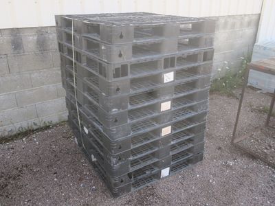 une pile de palettes en plastique posée devant un bâtiment