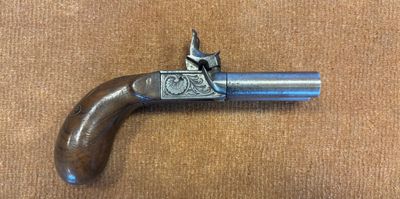 gros plan d'un pistolet sur une table à fond brun