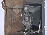 an old photo of an old camera with a leather case