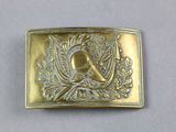 a gold belt buckle with a picture of a bird on it