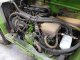 a green truck with a large engine in the back of it
