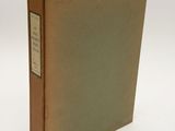 an old book sitting on top of a white table next to a white wall