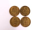four different types of gold coins on a white surface