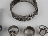 a lot of rings and bracelets that are on a table